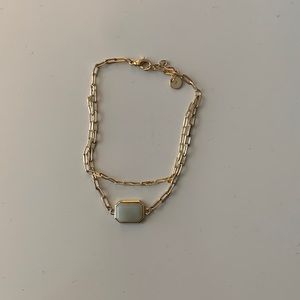 gold bracelet with a light teal stone